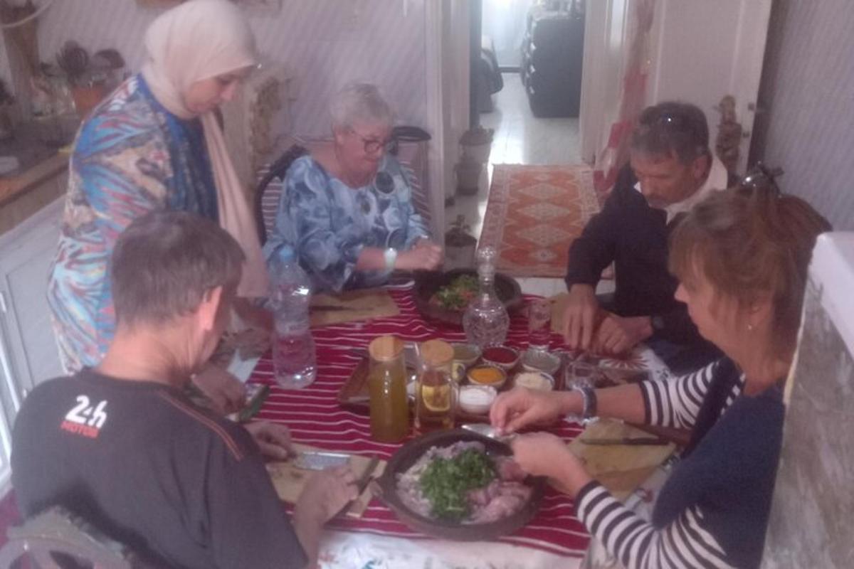 skupina lidí sedících kolem stolu a jedících jídlo