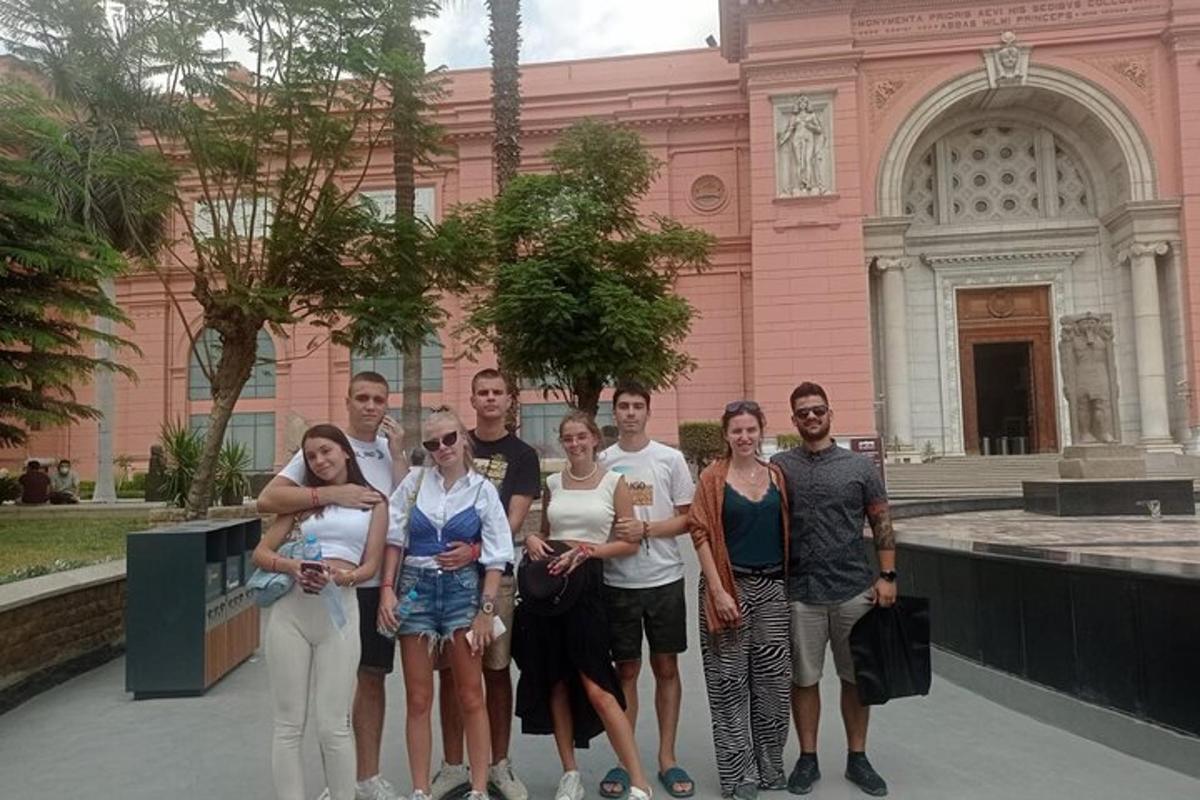 un gruppo di persone in piedi davanti a un edificio rosa