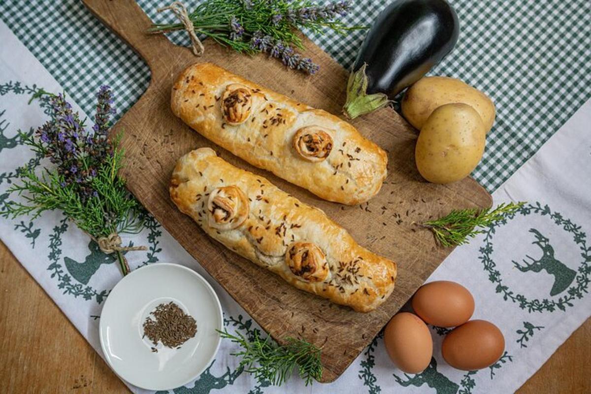 a wooden cutting board with rolls and eggs on a table