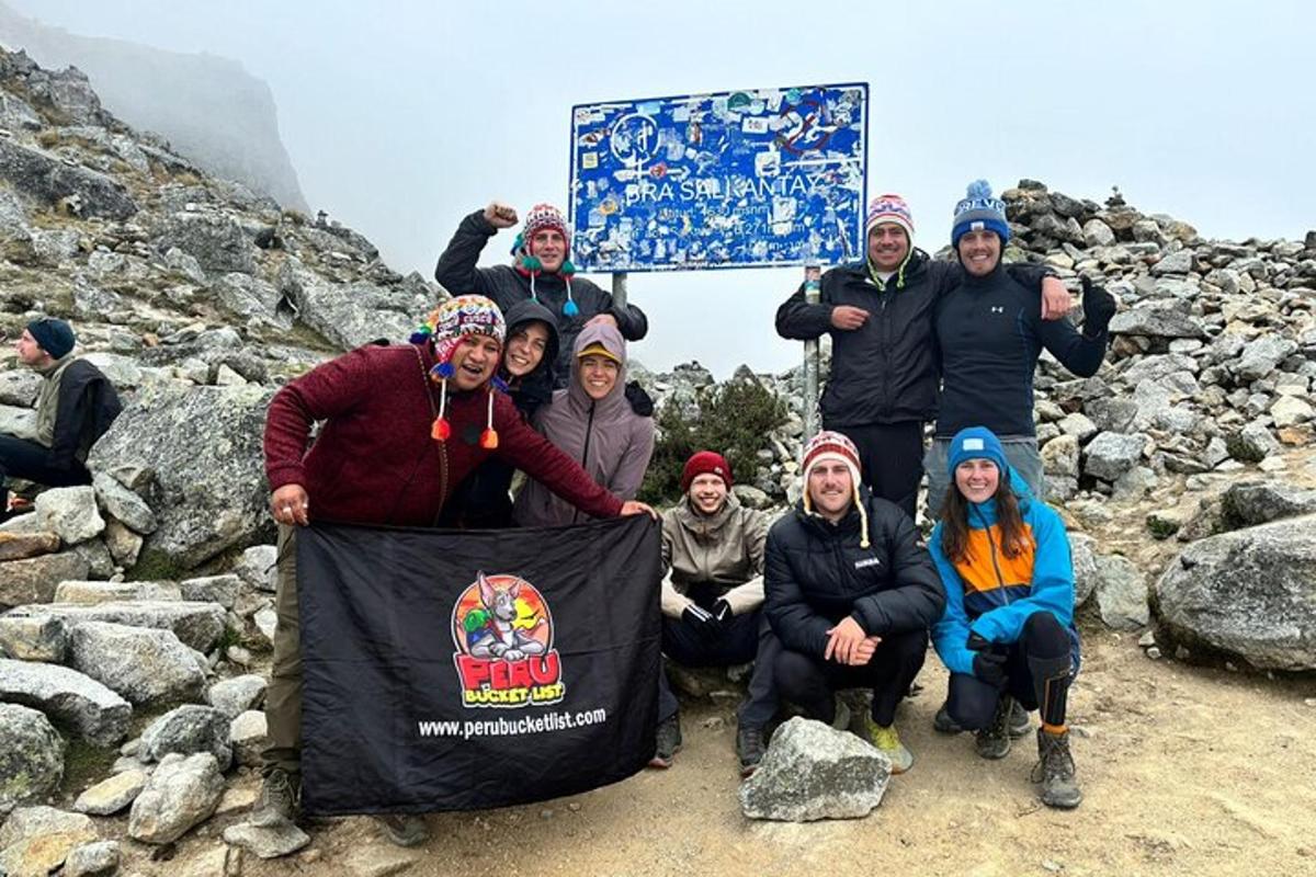 a group of people posing for a picture on a mountain