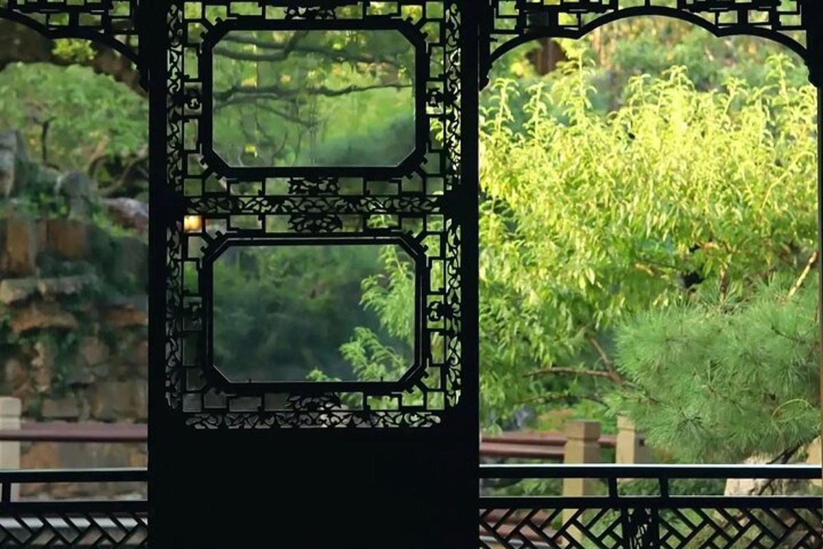 an open gate with two windows in a garden