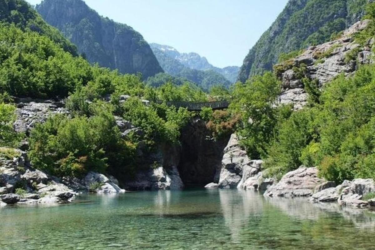 ein Fluss mit einer Brücke inmitten eines Berges