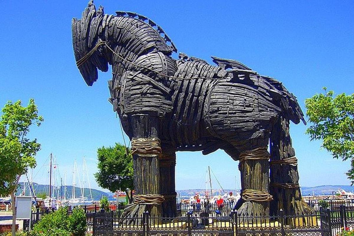 o statuie a unui cal de lemn care stă lângă un gard