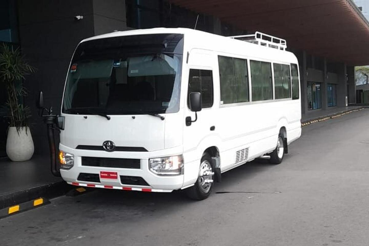 a white bus parked next to a building