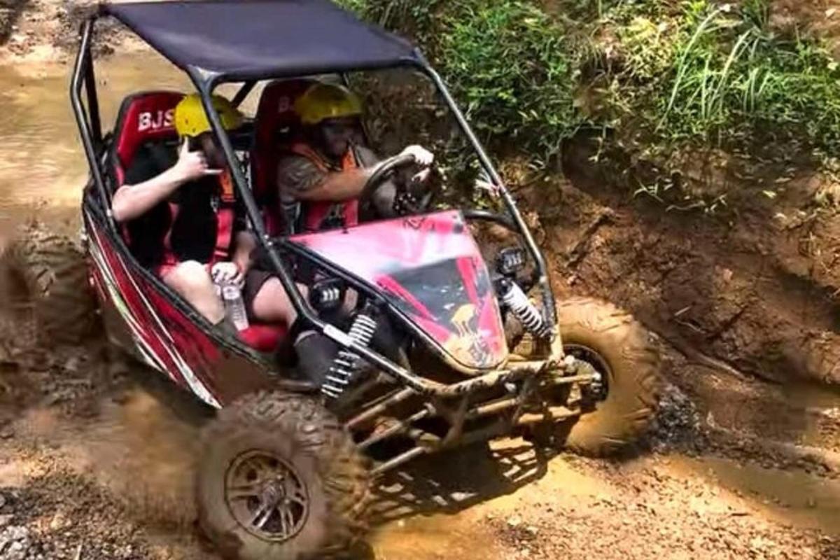 skupina lidí jedoucích na čtyřkolce po nezpevněné cestě