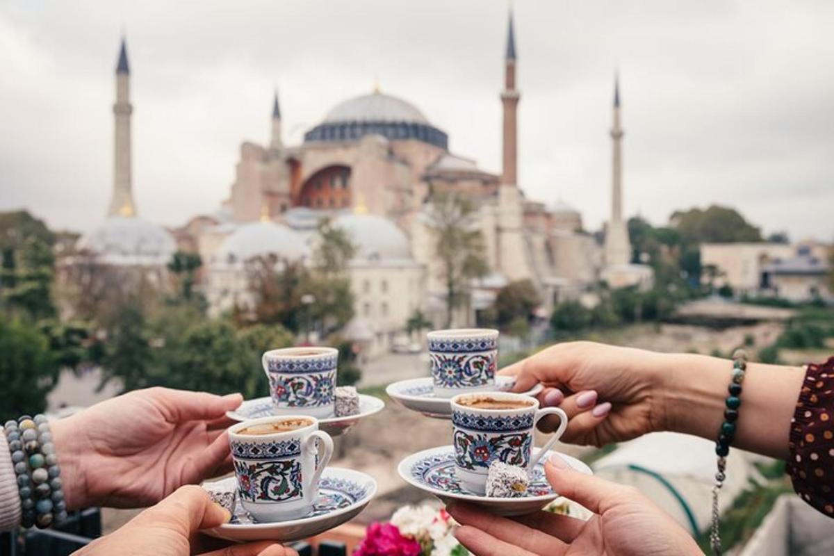 un groupe de personnes tenant des tasses de café devant une mosquée