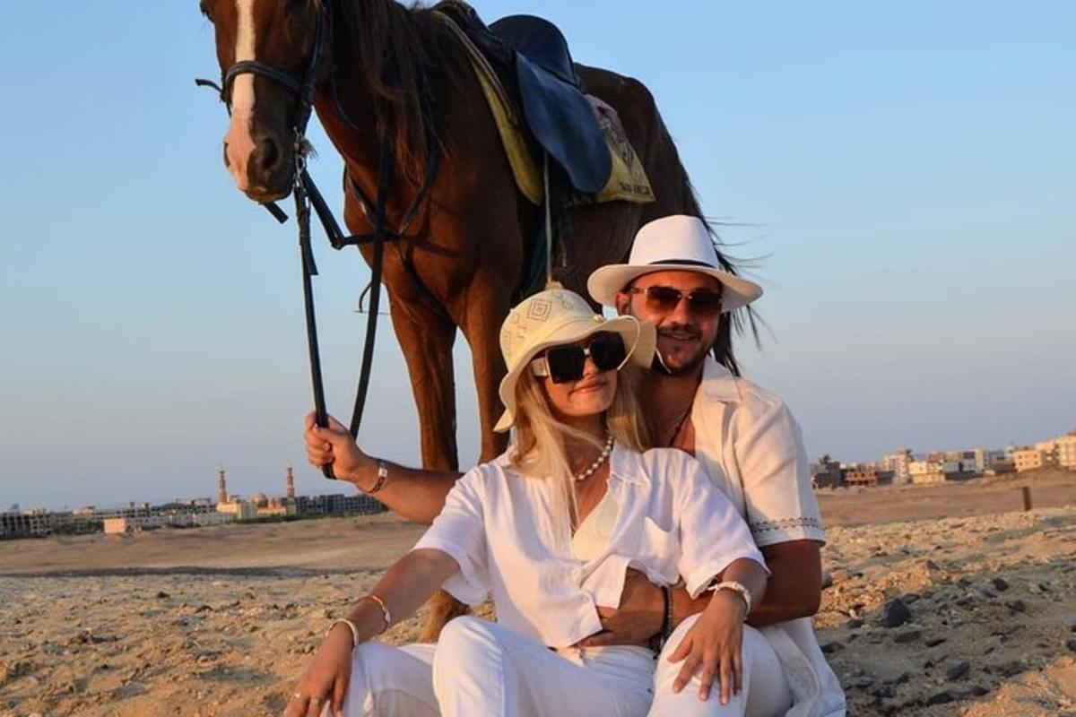 um homem e uma mulher sentados ao lado de um cavalo