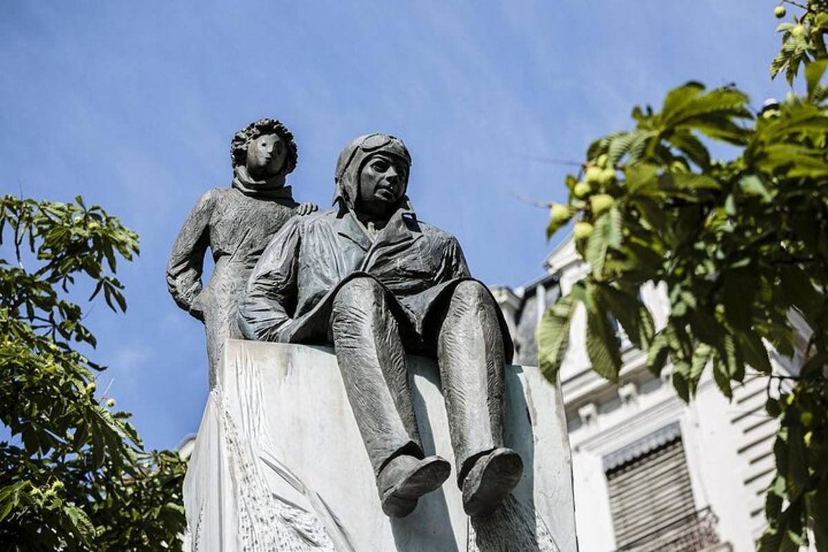 o statuie a unui bărbat așezat pe acoperișul unei clădiri