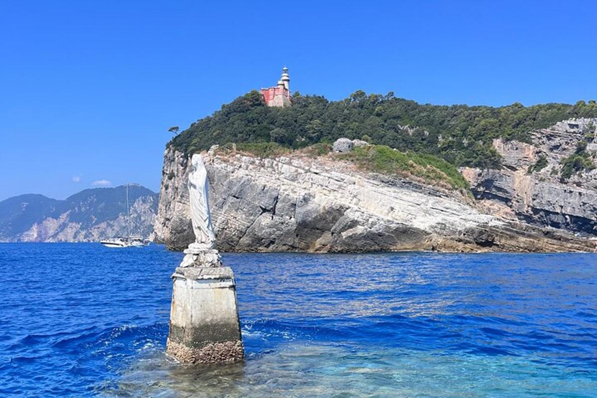 ένα άγαλμα στο νερό με έναν φάρο στο φόντο