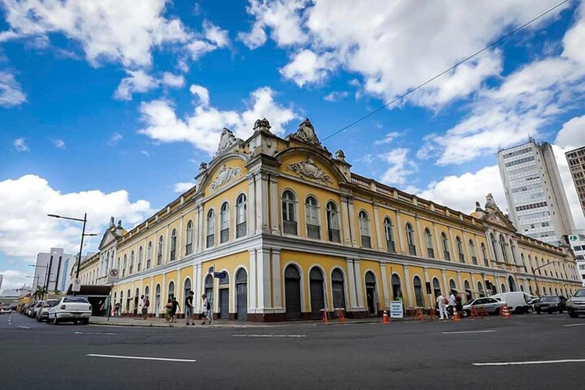 a large yellow building with a clock on it