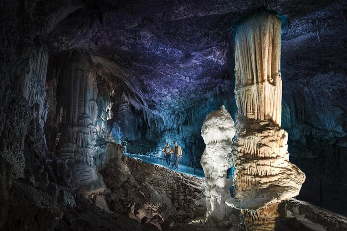 a cave with two people standing inside of it