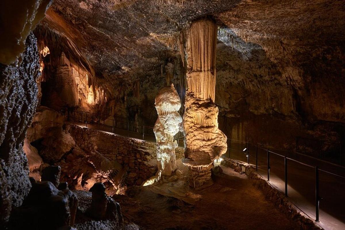 a group of people in a cave with a rock pillar