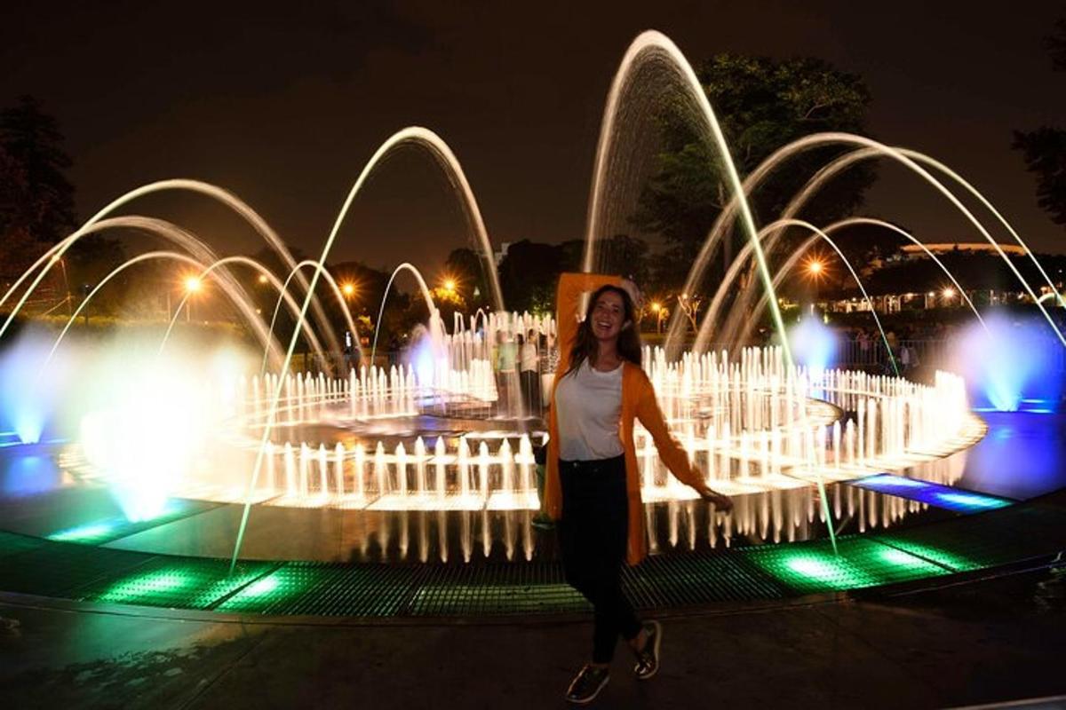 una donna in piedi davanti a una fontana di notte