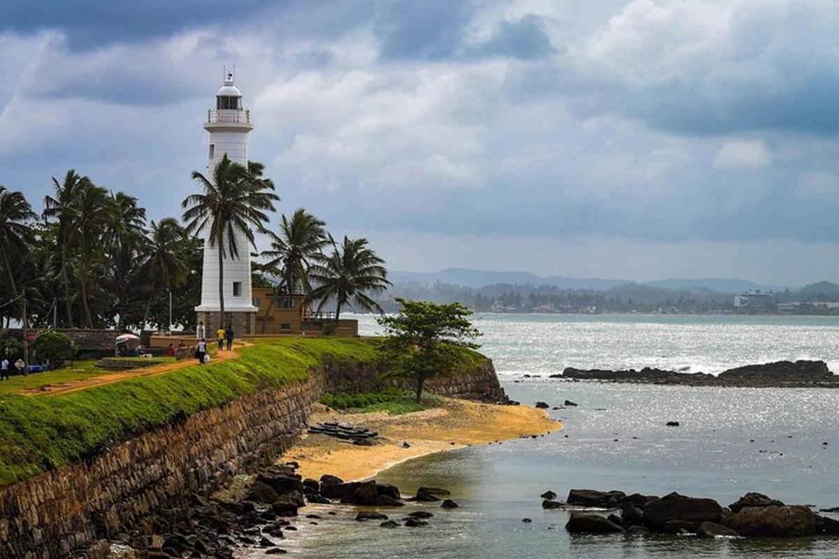 un faro sulla riva di una spiaggia con uno specchio d'acqua