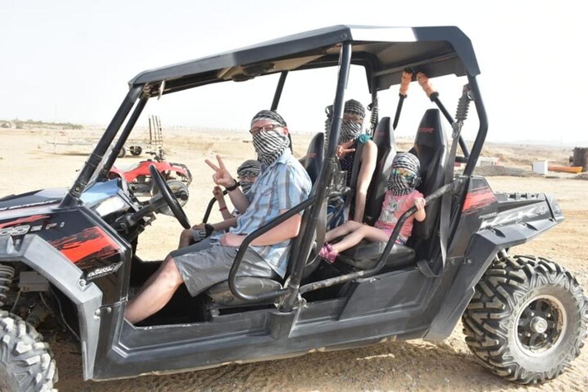 Un grupo de personas sentadas en un vehículo en el desierto.
