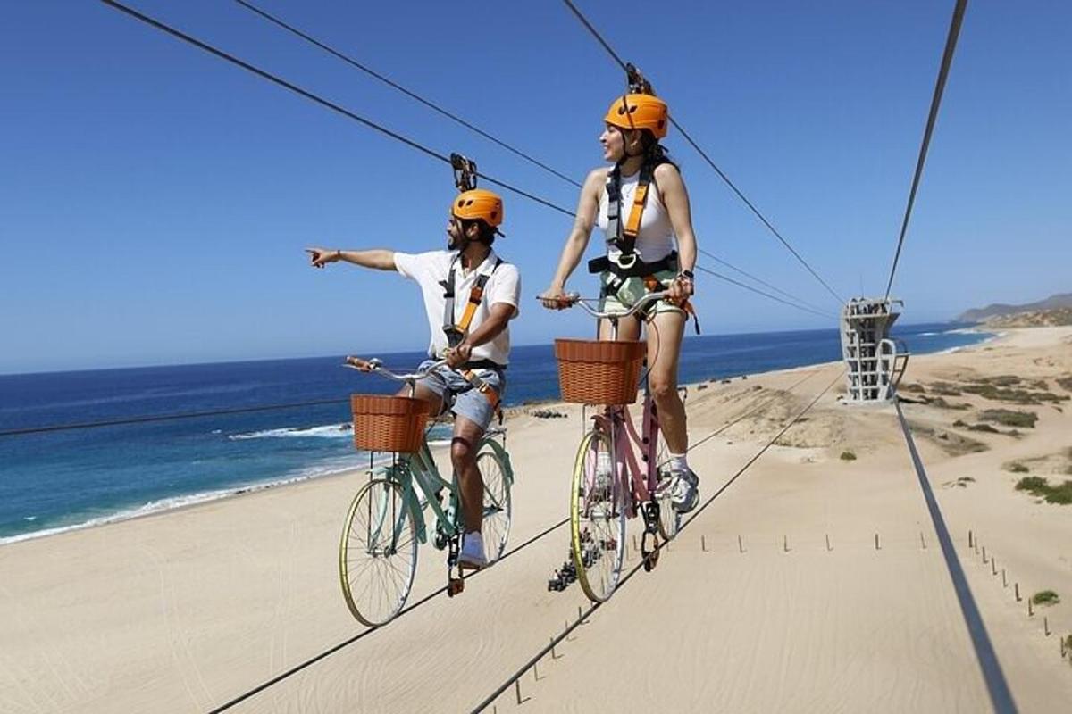 dva lidé jedoucí na kolech na zipline nad pláží