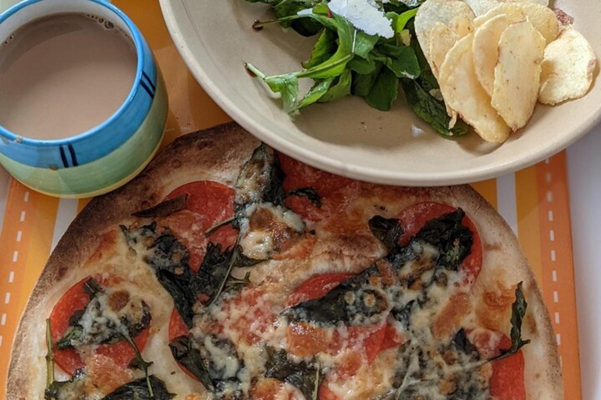 en tallerken med pizza og en salat og en kopp kaffe