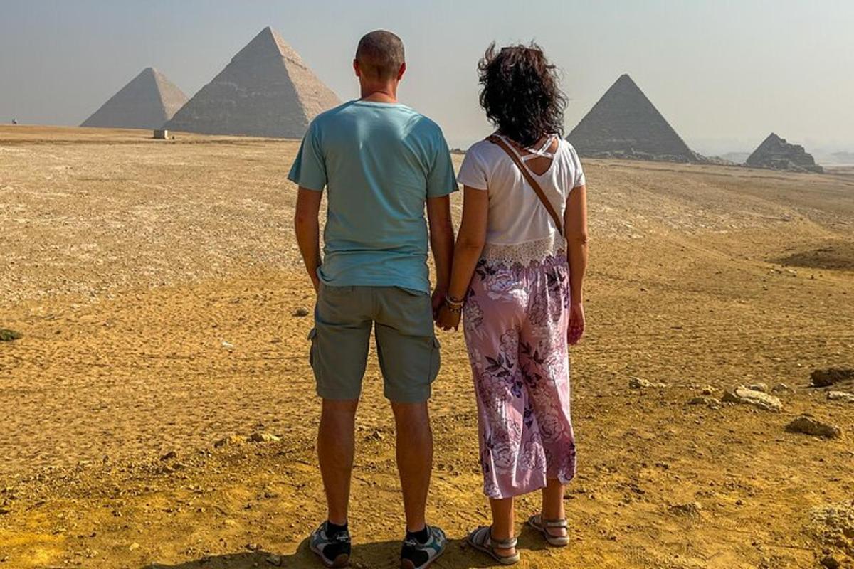 un uomo e una donna in piedi davanti alle piramidi