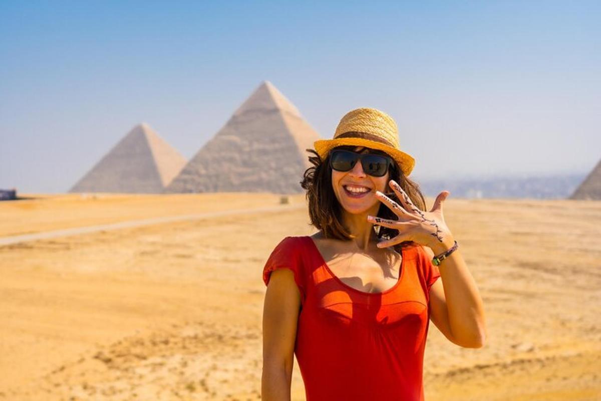 una donna che parla al cellulare davanti alle piramidi