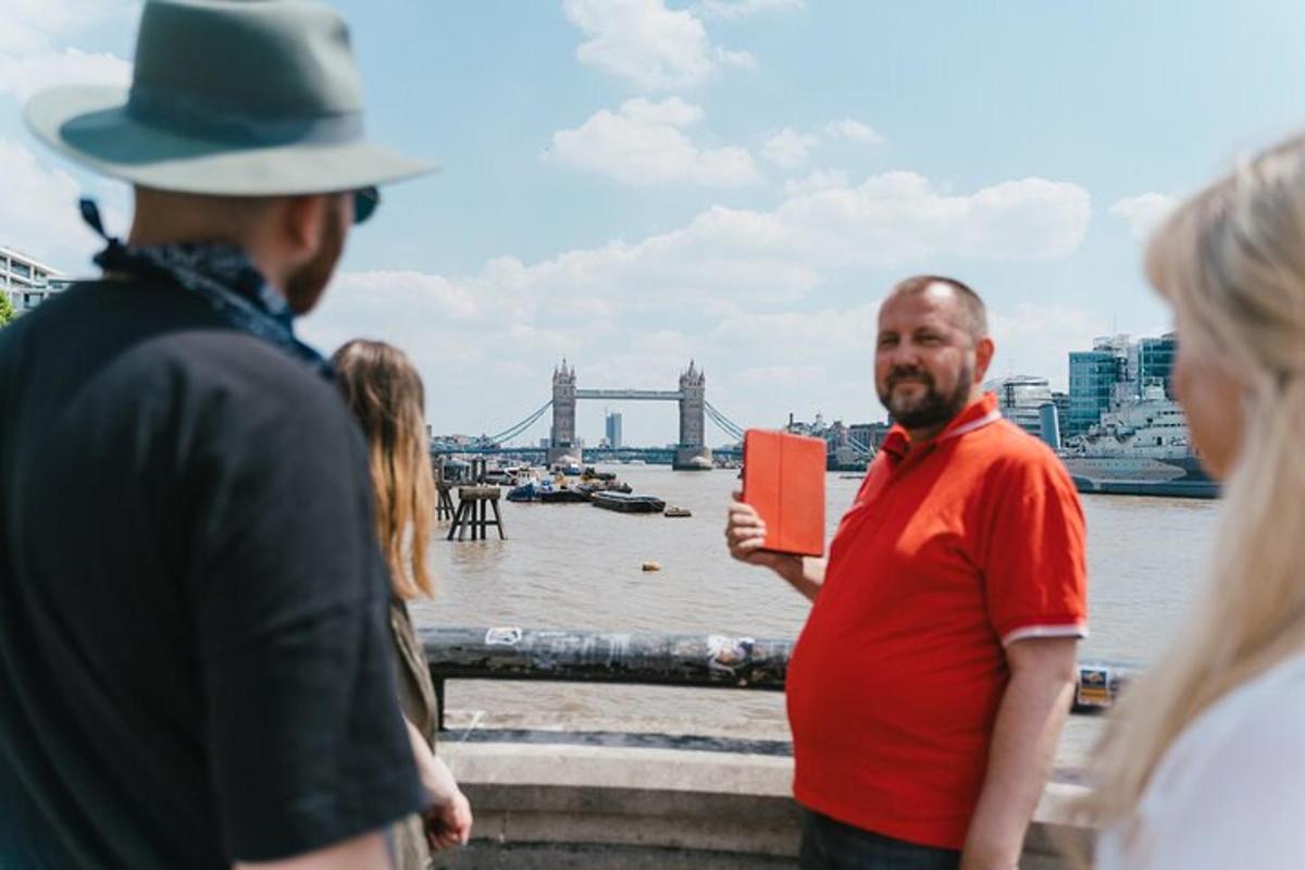 un uomo che tiene in mano un libro rosso davanti a un fiume