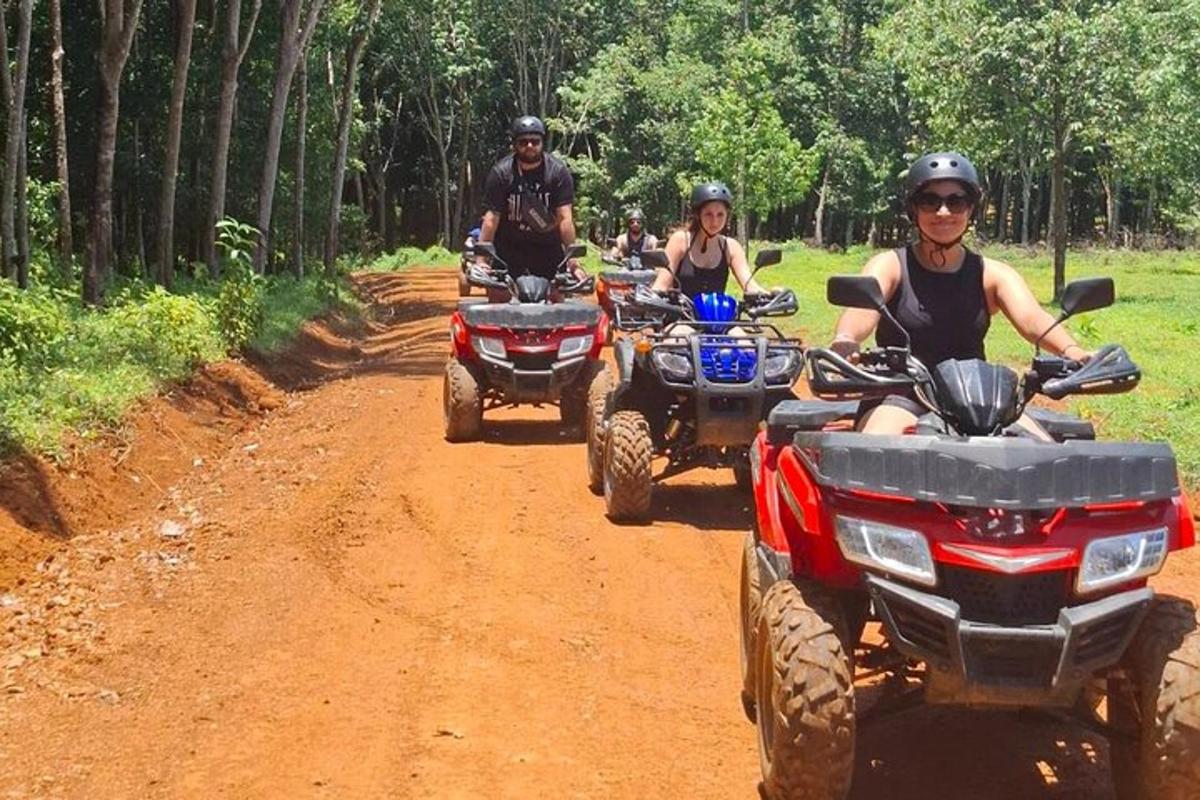 a group of people riding atvs on a dirt road