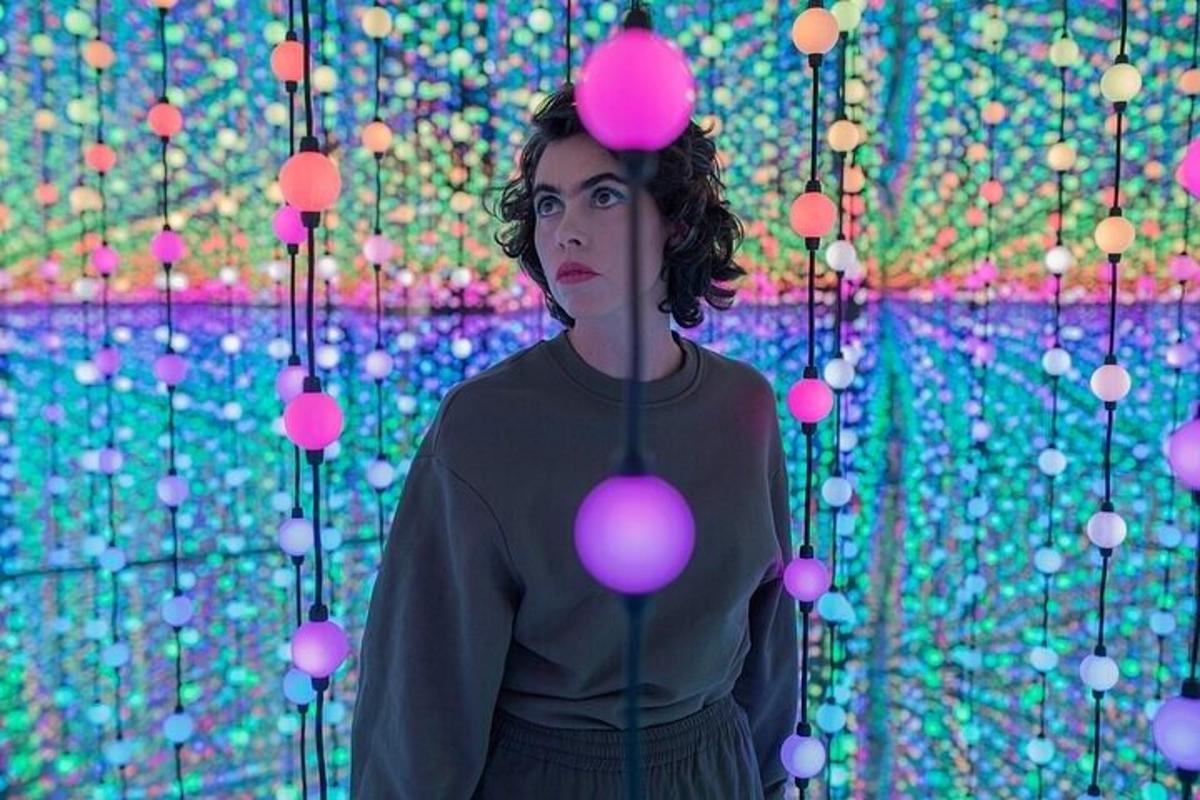 a woman standing in front of a wall of balls