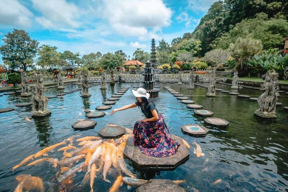 Una niña sentada en una roca en el agua en un jardín.