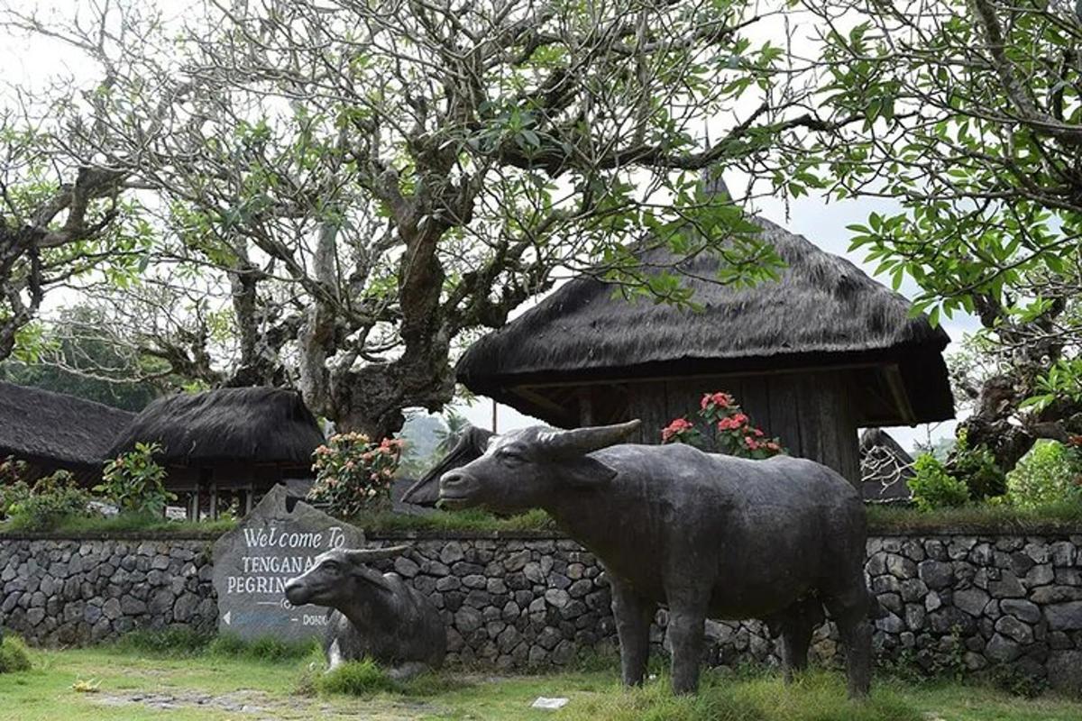 una statua di una mucca accanto a un muro di pietra