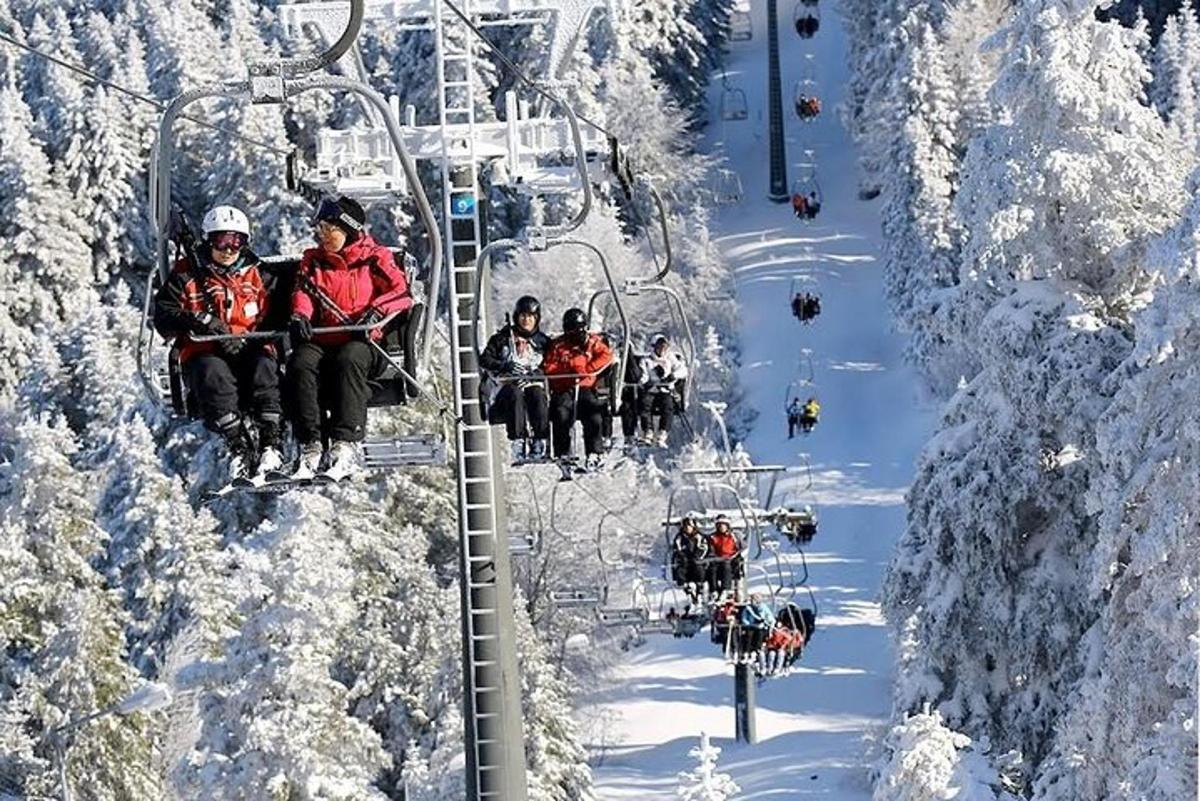 sekumpulan orang menaiki lif ski di dalam salji