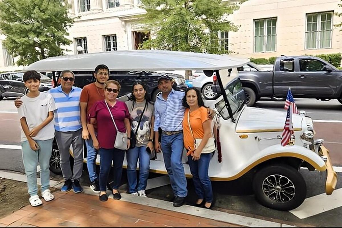 a group of people standing in front of a small car