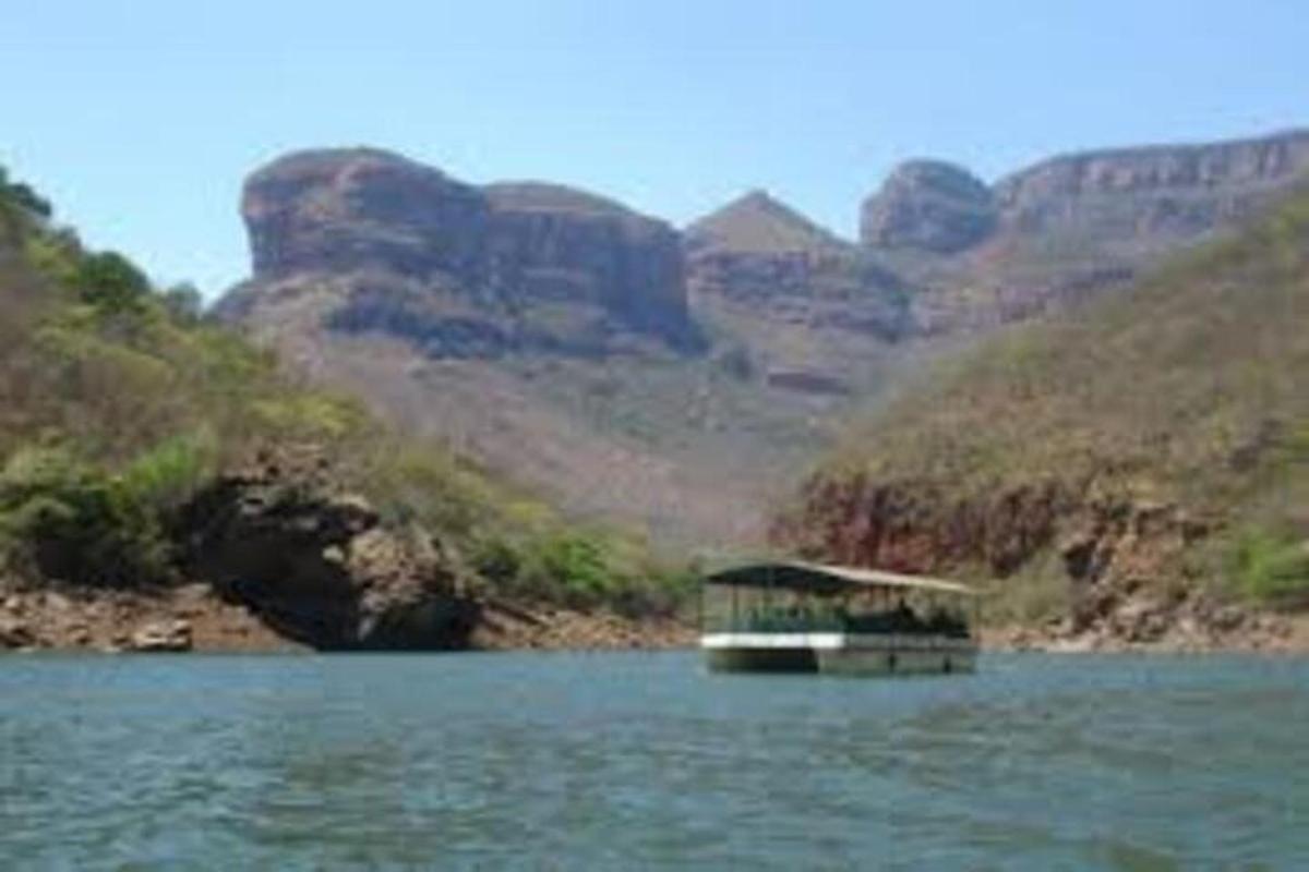 a boat on a river with mountains in the background