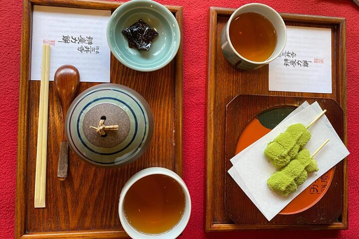 dřevěný tác s hůlkami a šálky čaje a sushi