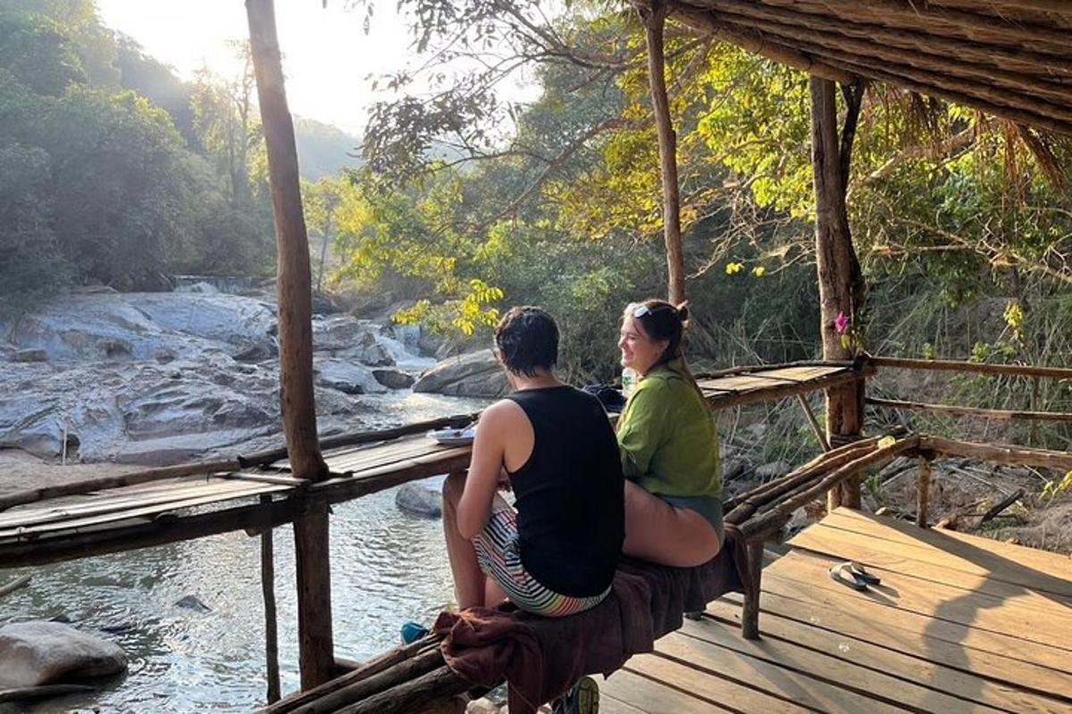 un homme et une femme assis sur un pont surplombant une rivière