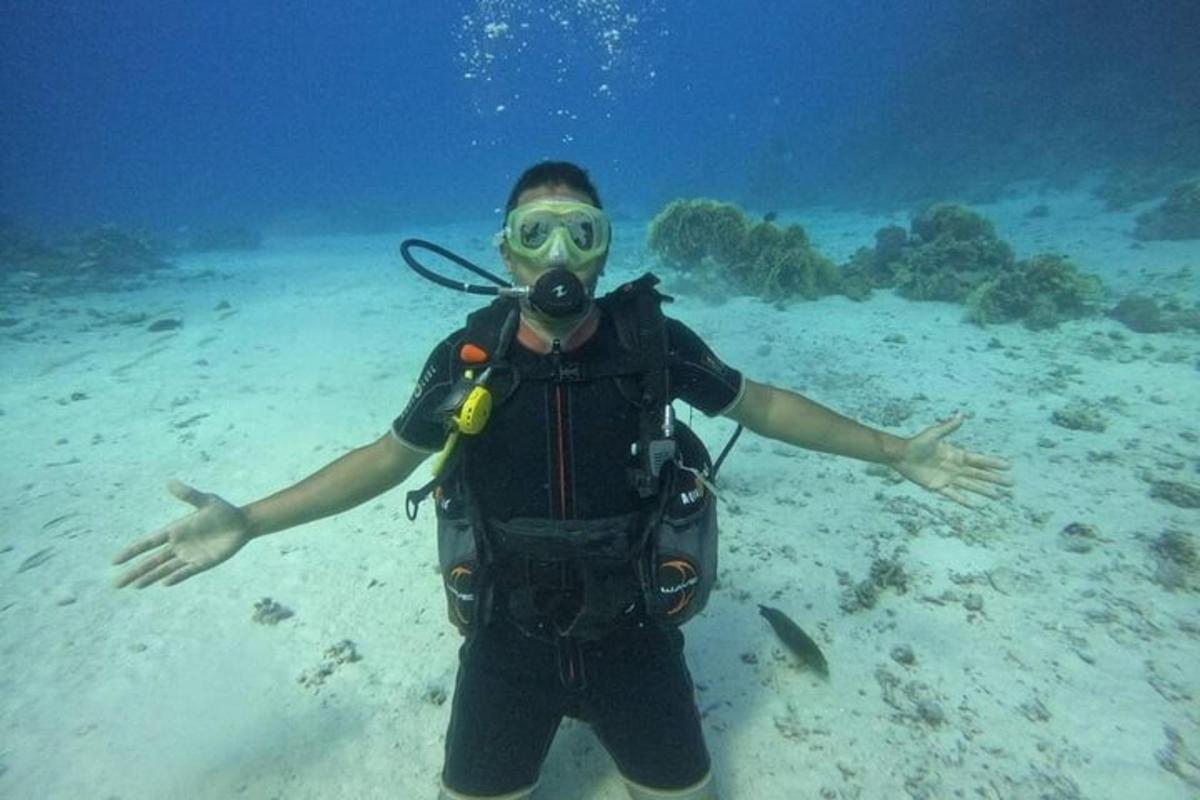 um homem em um traje de mergulho parado no oceano