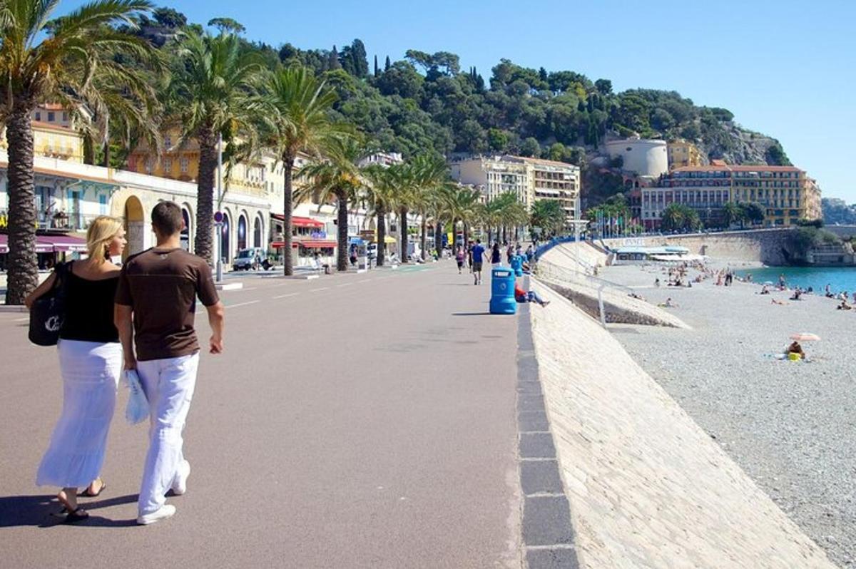 moški in ženska, ki se sprehajata po plaži