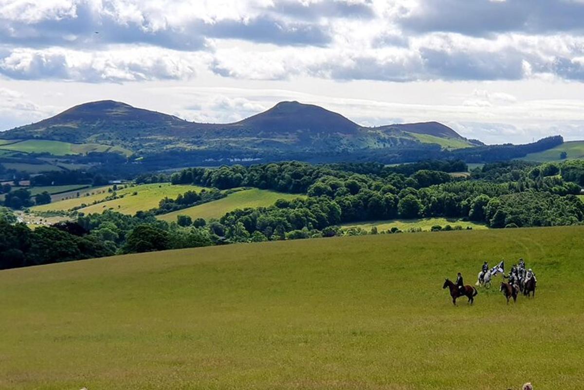 a group of people riding horses in a field