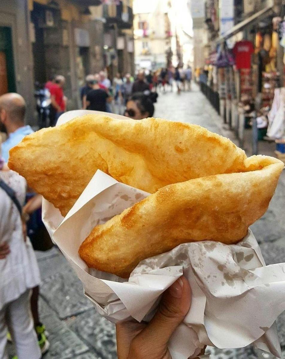 a person is holding a piece of food in a hand