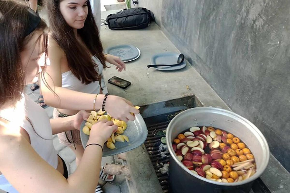 due giovani donne stanno mangiando frutta in un secchio