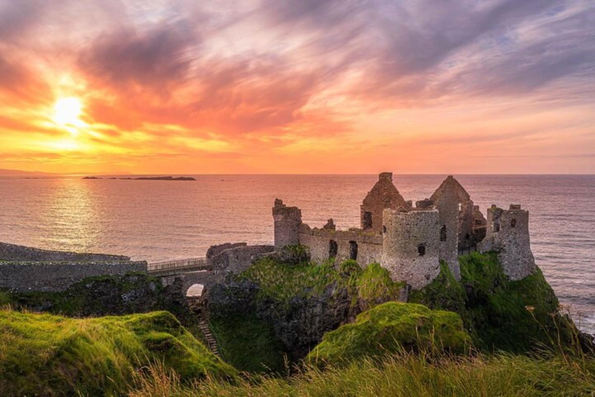 an old castle on the shore of the ocean at sunset