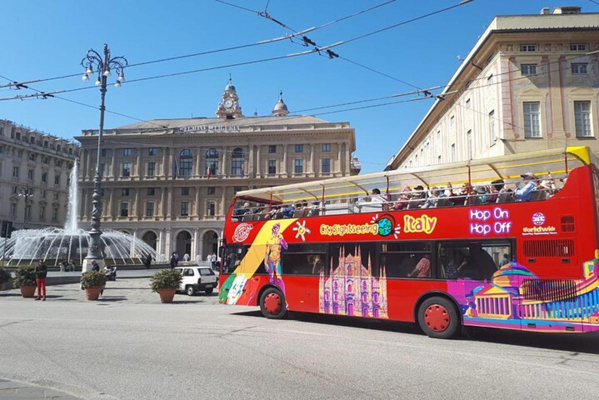punane kahekordne buss sõidab mööda linnatänavat