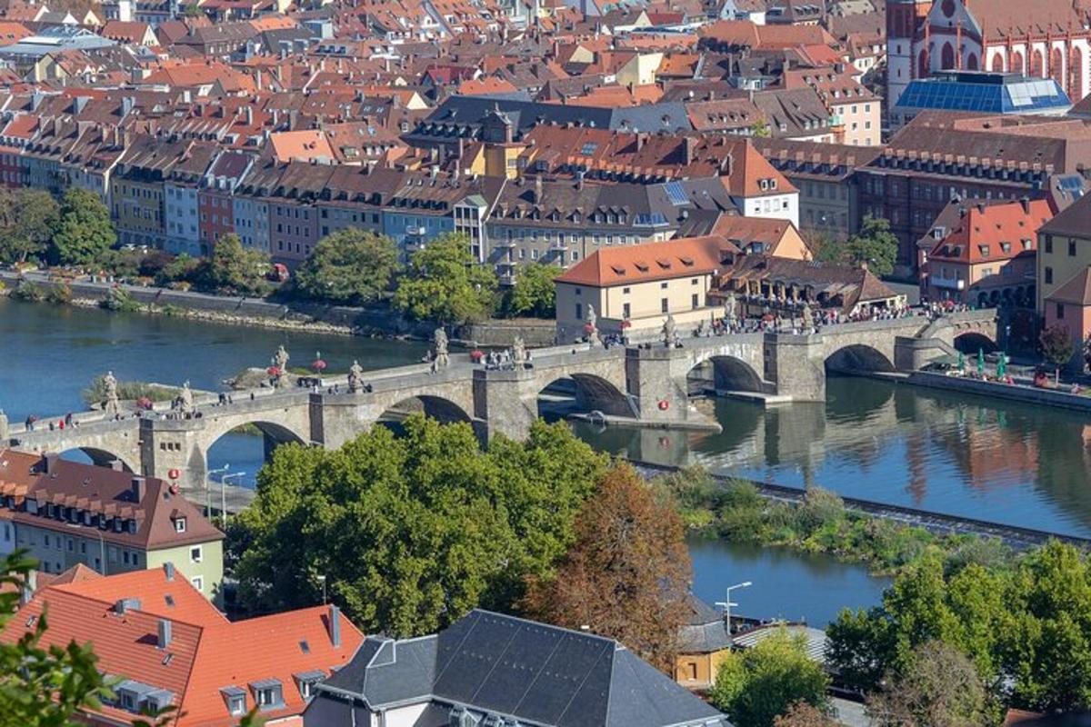 a bridge over a river in a city with red roofs