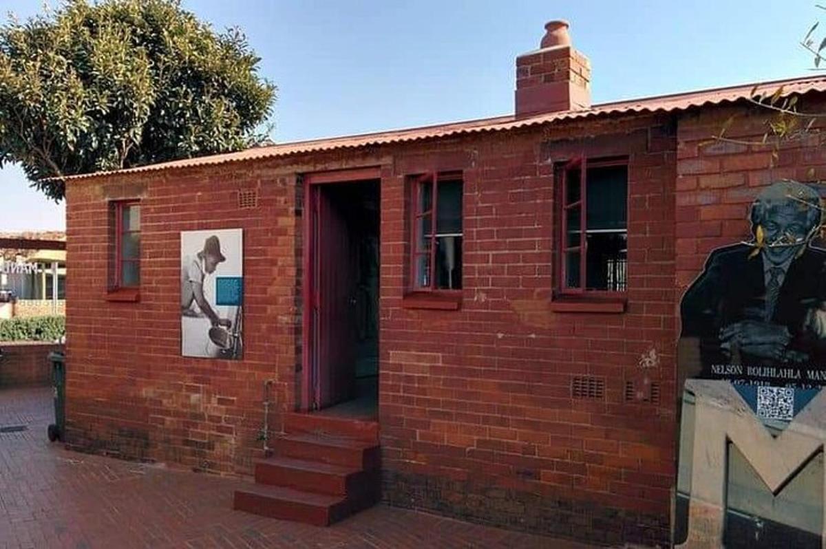 a brick building with a door and a bust of a man