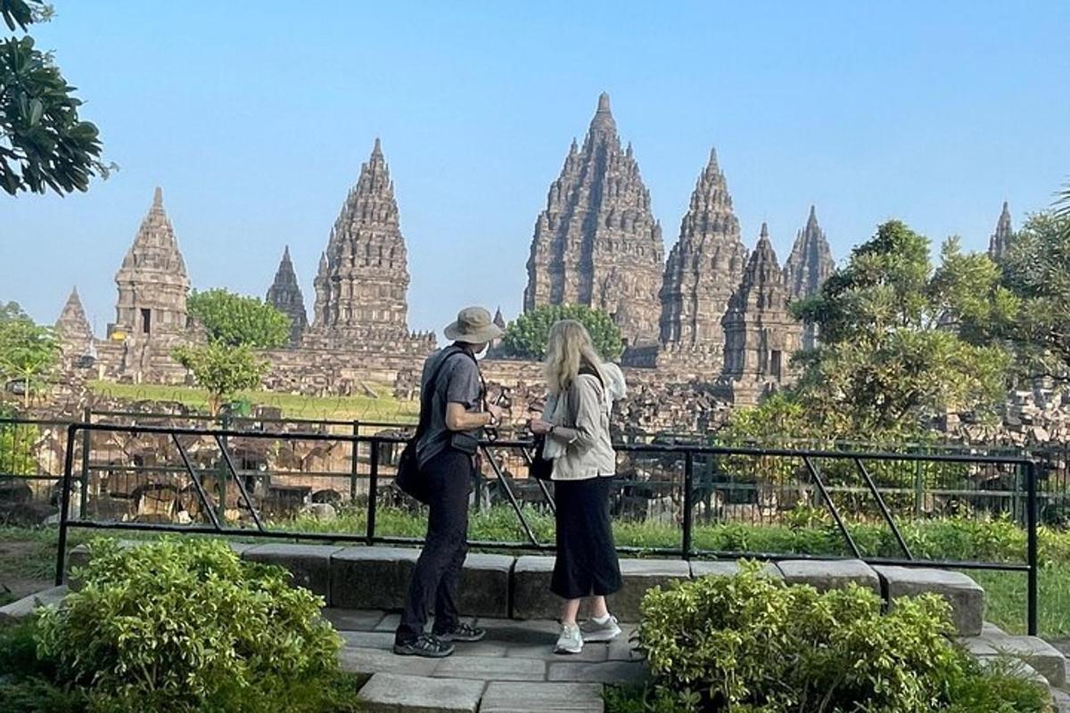 un homme et une femme debout devant un temple
