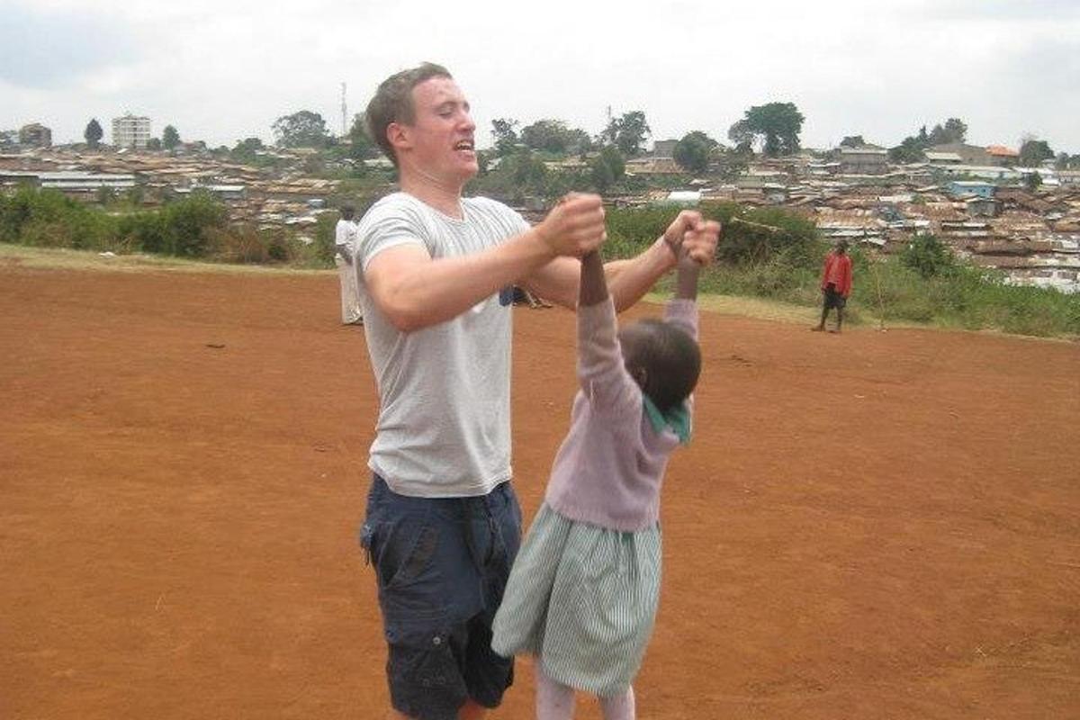 a man and a little girl holding their hands in the air