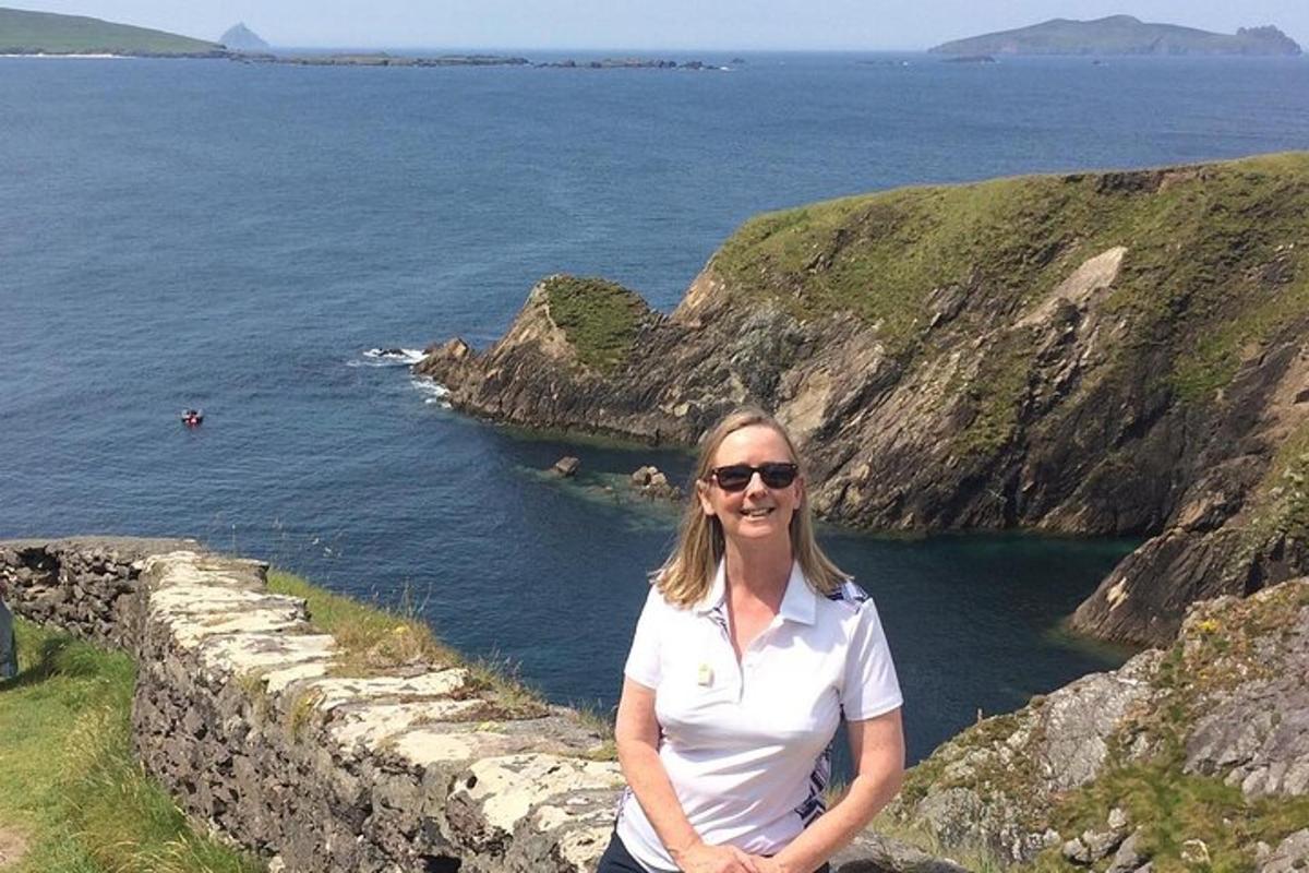 una donna in piedi su un muro vicino all'oceano