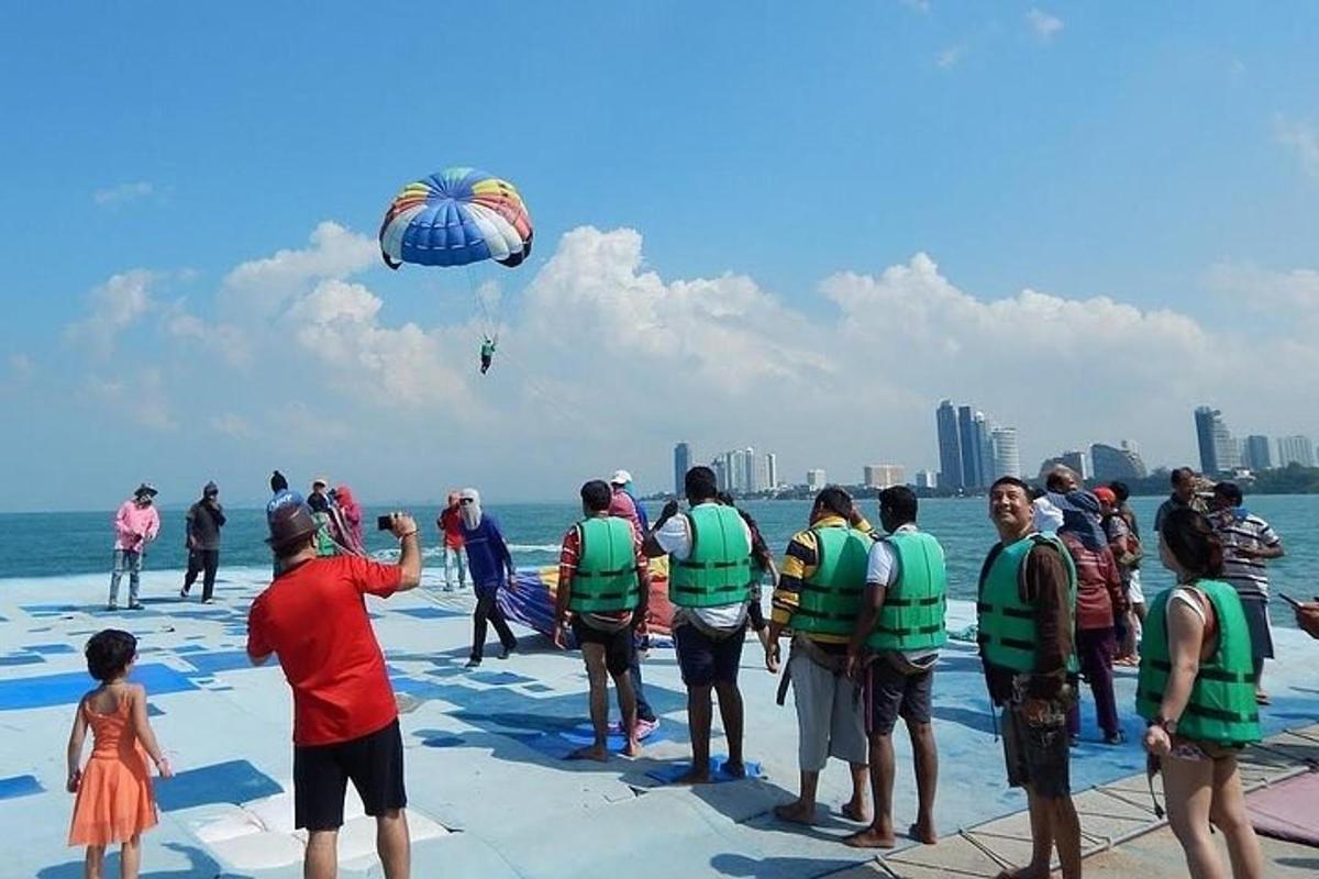 sekumpulan orang berdiri di pantai menerbangkan layang-layang