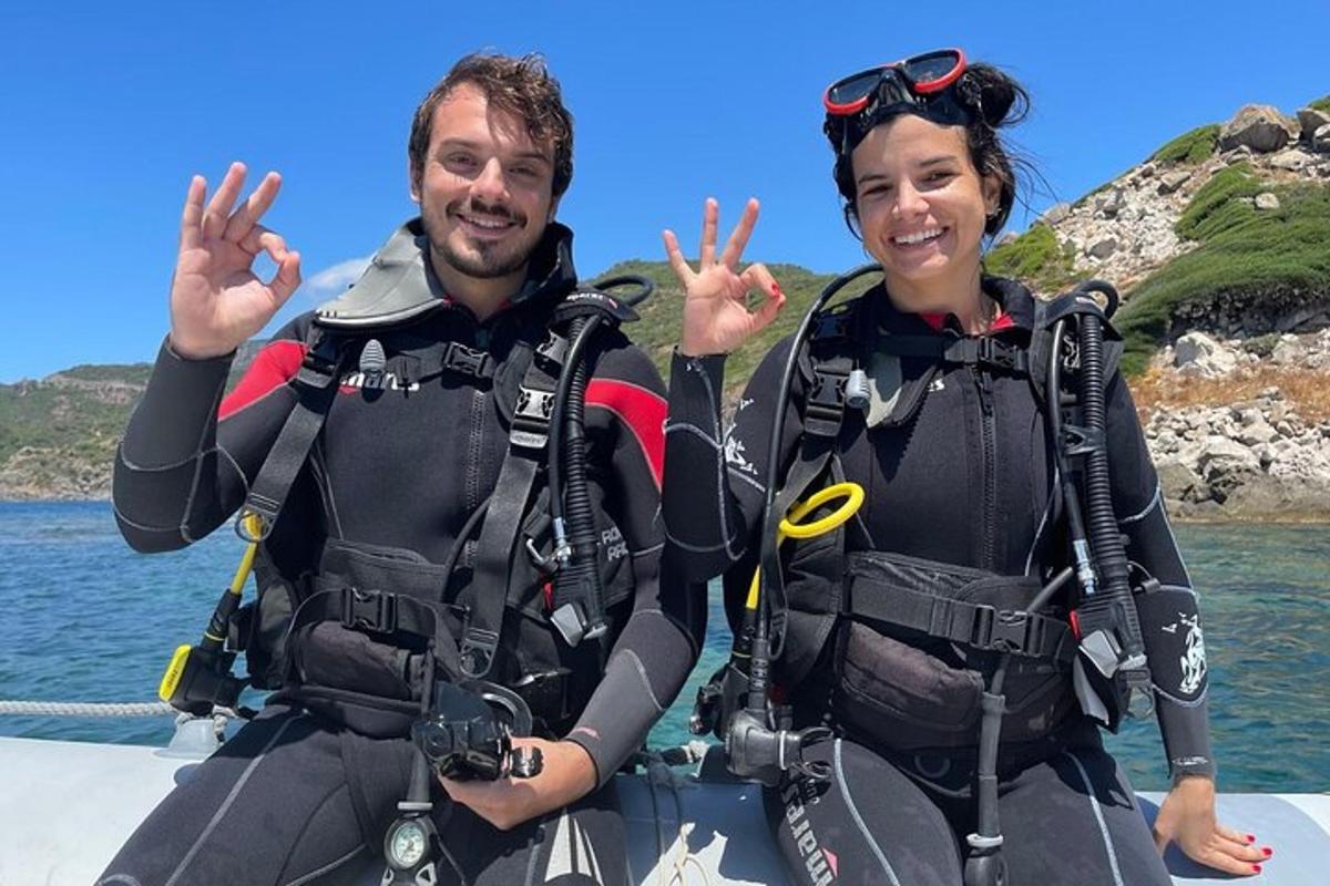 a man and a woman in scuba gear on a boat