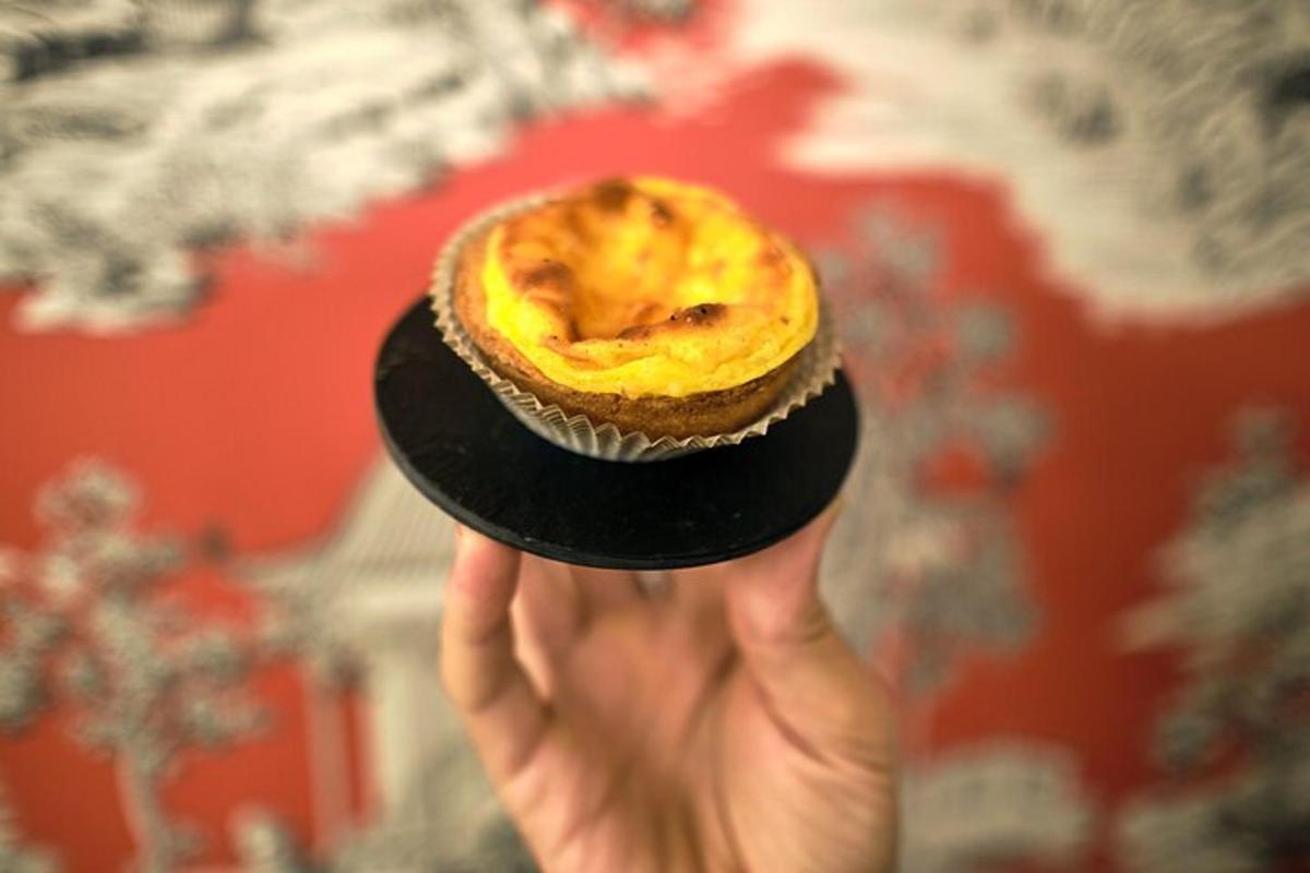 Ένα χέρι που κρατά ένα cupcake σε ένα μαύρο πιάτο