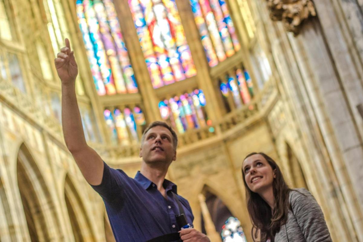 Un hombre y una mujer de pie en una iglesia con la mano en el aire.