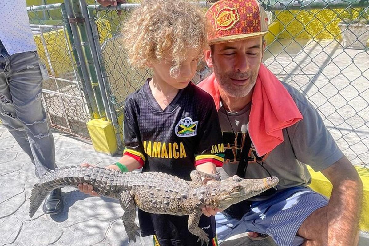 moški, ki drži krokodila z mladim fantom